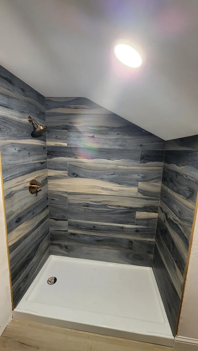 bathroom shower with black tile niche
